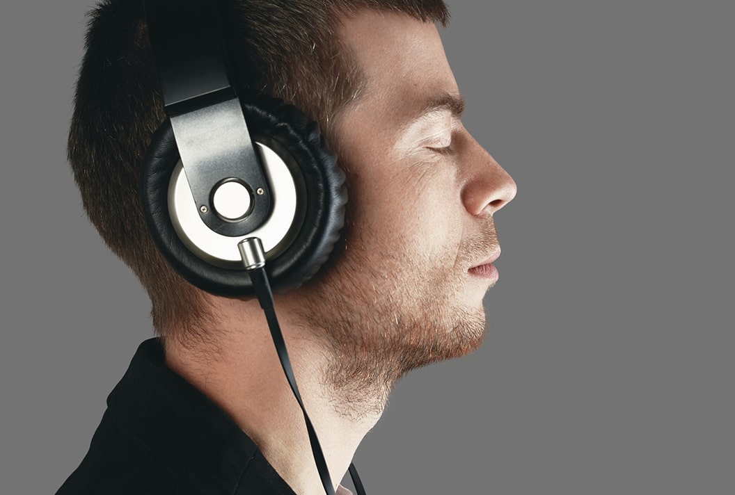 Hombre de perdil con los ojos cerrados y auriculares